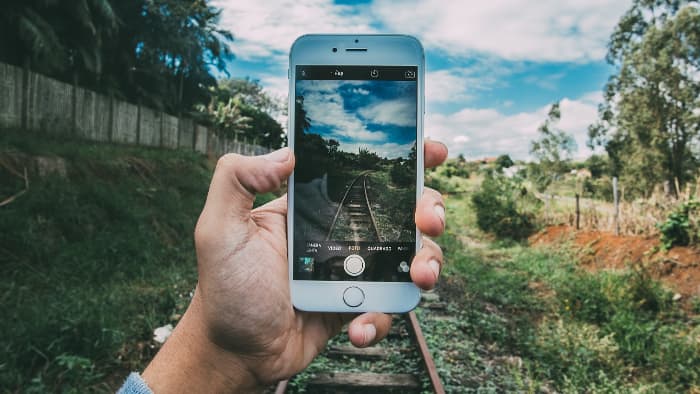 A phone taking a photo of a railway track.