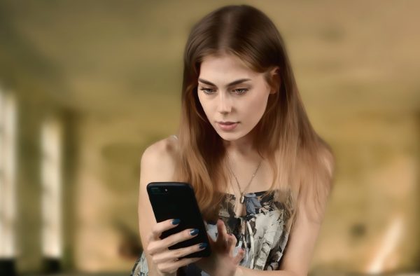 A woman staring intently at a smartphone