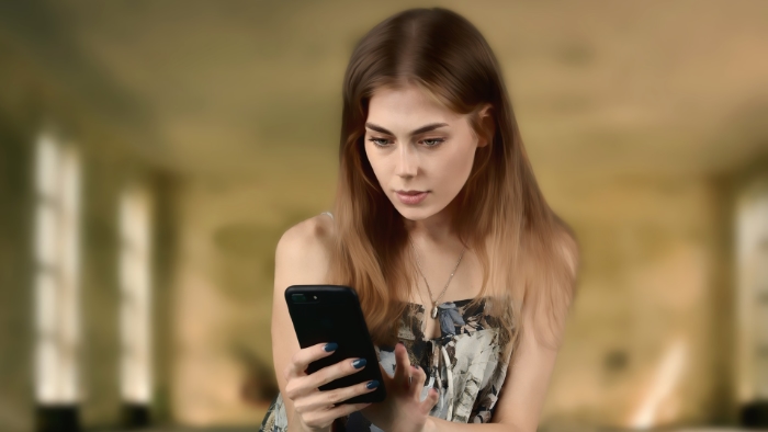 A woman staring intently at a smartphone